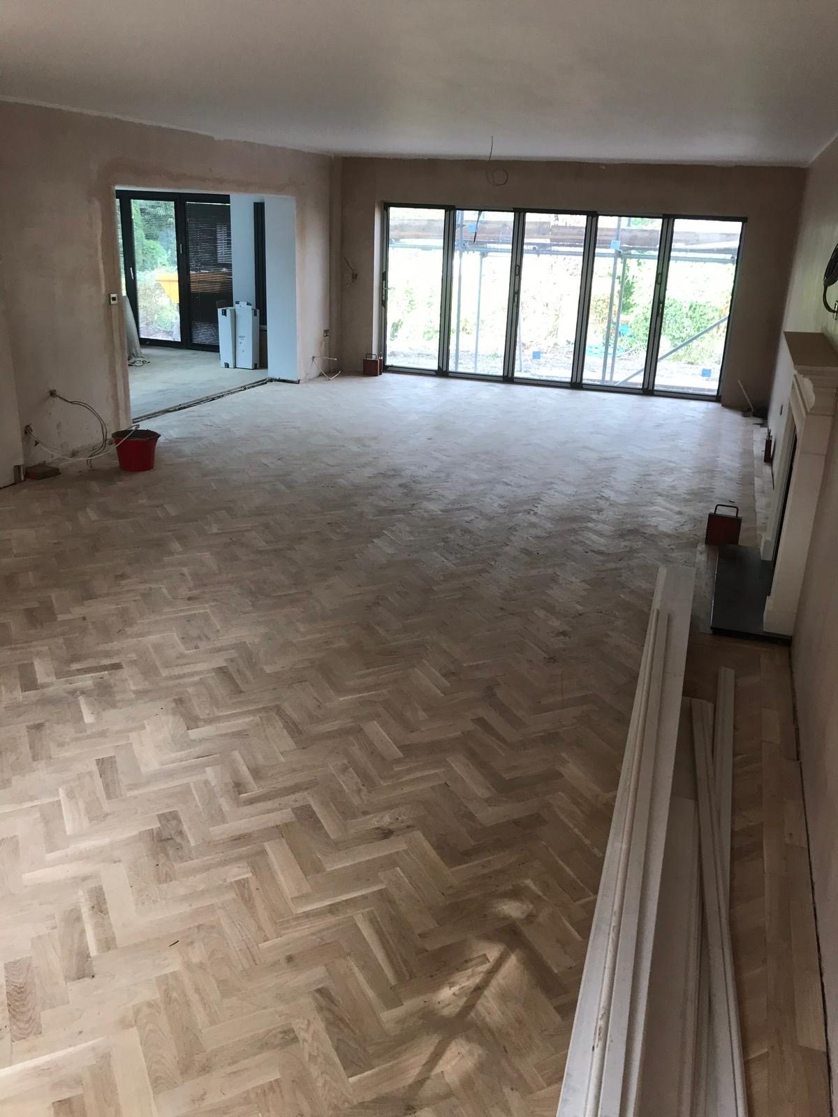 Interior of a completed rear extension with patio doors and engineered wood floor