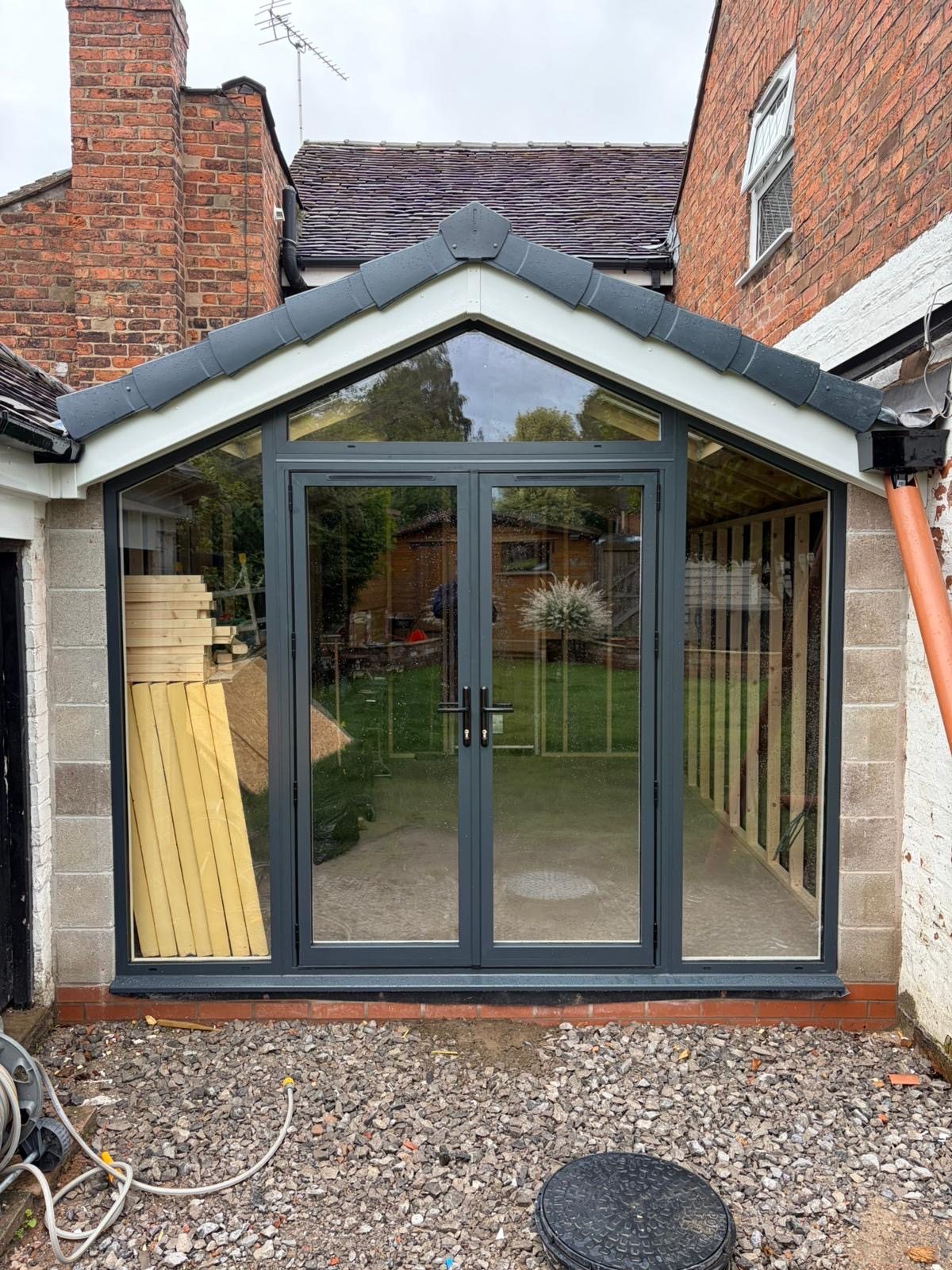 Glazed garden room with aluminium French doors and a pitched tiled roof